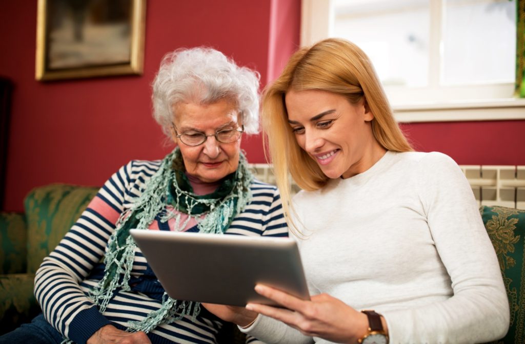 An adult child and their senior parent look at adult day center and respite care options to provide a break for the adult caregiver.