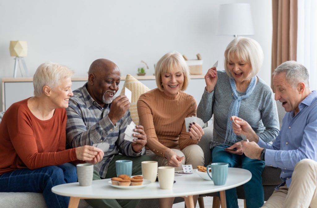 A group of happy-looking seniors play a card game together.