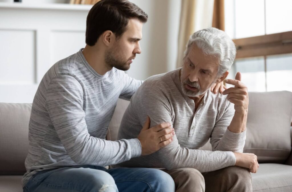 A stressed adult child trying to comfort their frustrated older parent.
