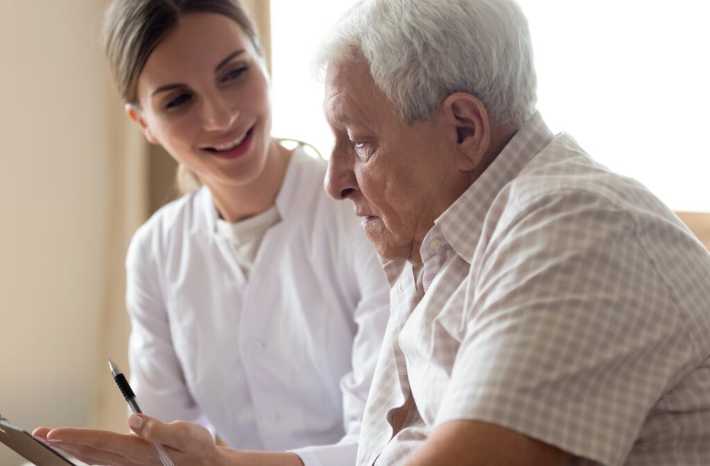 Senior man talking to nurse regarding payments available for assisted living